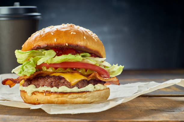 istock Hamburger and paper cup on dark background 1204476842