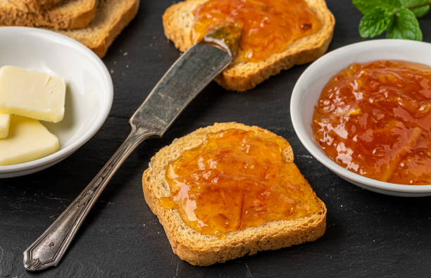 istock Orange marmalade on top of crispy toast bread. 1204478233