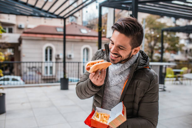 istock Young man eating fast food 1204478313