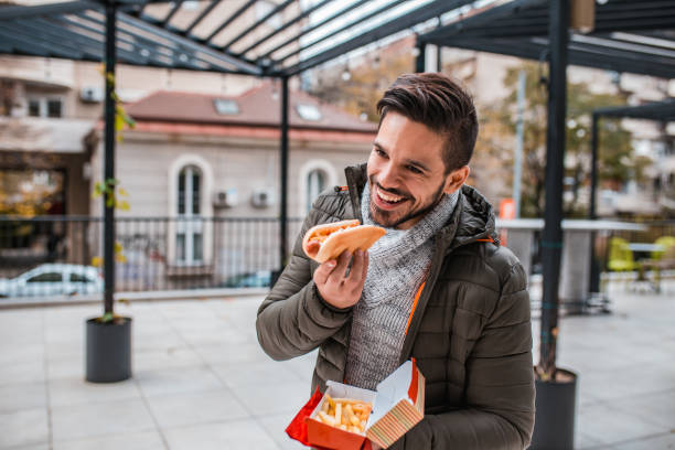 istock Young man eating fast food 1204478371