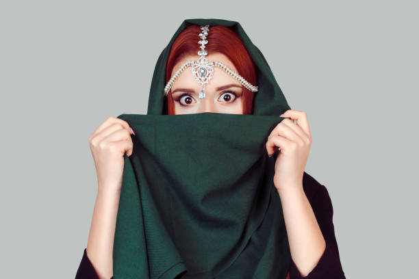 衝撃。美しい女性は、緑の布のスカーフで彼女の顔を大きく開いて目をショックを受けました。ファッションイスラムスタイルの女の子 - green tika ストックフォトと画像