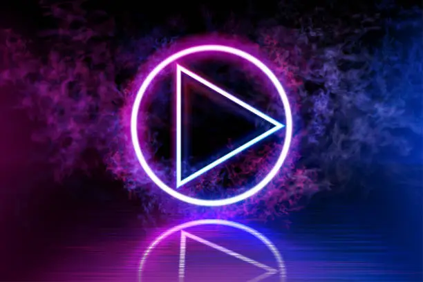 Vector illustration of Neon color player sign on a dark background. Right arrow in a circle, luminous line, sign. Dark space, reflection of blue and pink neon light on the floor. Rays of light in the dark, smoke. Vector.