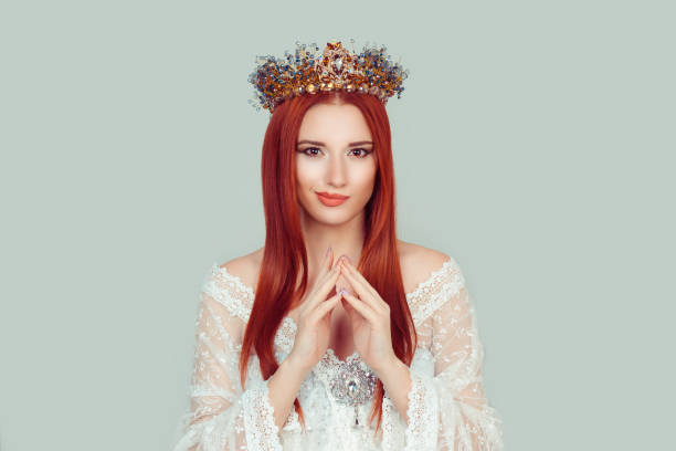 istock Plotting beauty queen. Closeup portrait of sneaky, sly, scheming young woman plotting something pretty woman with crystal crown on head isolated on light green gray background wall. 1204480341