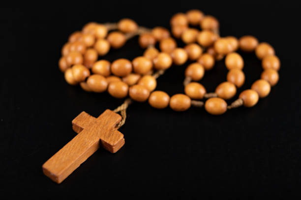 istock Wooden rosary arranged on the table. Prayer accessories. Dark background. 1204482409