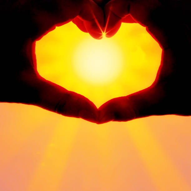 istock Hands forming a heart shape over the sun 1204484224