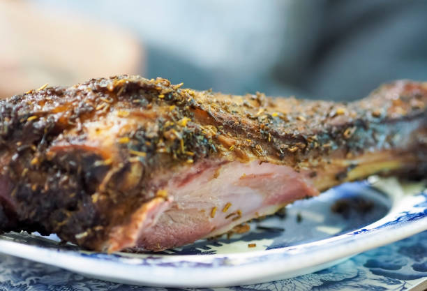 Freshly roasted lamb shank on a plate that has been carved