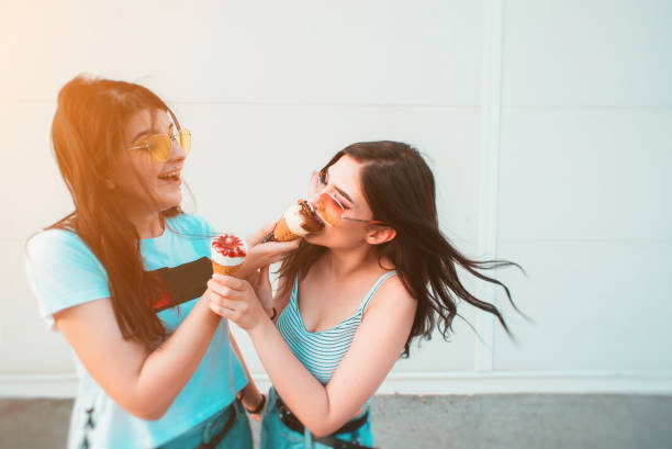 istock Two young female friends sharing ice cream 1204486312