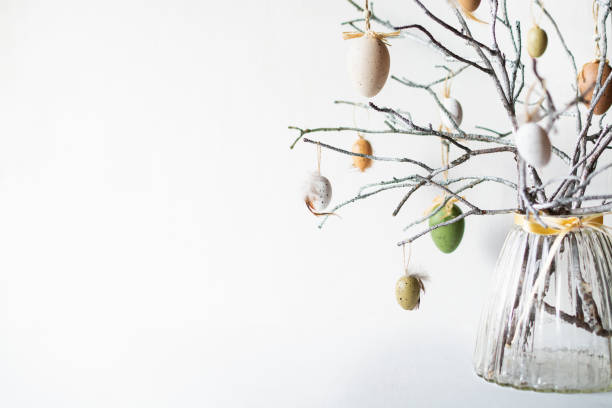 still life with tree branches decorated with easter eggs and feathers in glass vase - easter easter egg eggs spring imagens e fotografias de stock