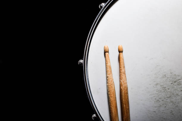 istock Drum stick and drum on black table background, top view, music concept 1204492126