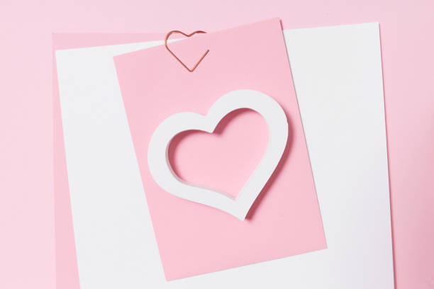 istock Empty template for romantic letters on a pink background. White feather with gold plating. Real photo, flat lay. Copy space for text. 1204492946