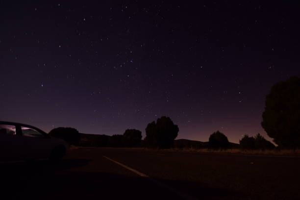 istock Wide Angle View From Roadside With Car Against Clear Star Filled Night 1204496772