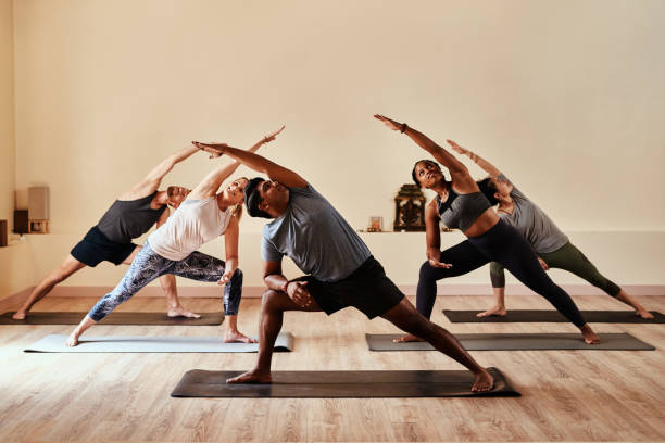 joga pozwala twojemu wewnętrznemu wojownikowi poluzować - yoga class caucasian young adult group of people zdjęcia i obrazy z banku zdjęć