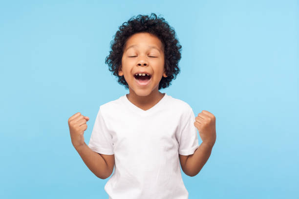 아이 승리, 성공. 손을 들고 승리와 행운을 기뻐하는 비명을 지르는 티셔츠에 흥분한 어린 소년의 초상화 - surprise shouting child black and white 뉴스 사진 이미지