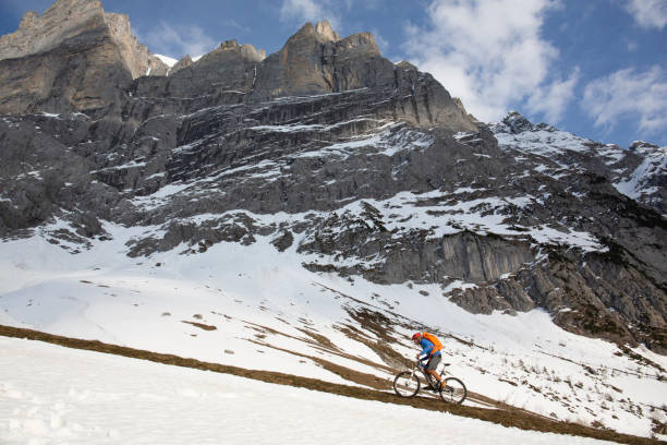 istock Mountain biker ascends steep mountainside 1204510597