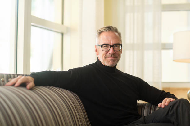 istock Portarit of a handsome older man sitting on a sofa 1204523660