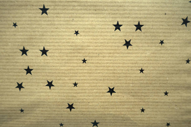 istock Kraft paper decorated with multiple stars  Gift wrap 1204531377