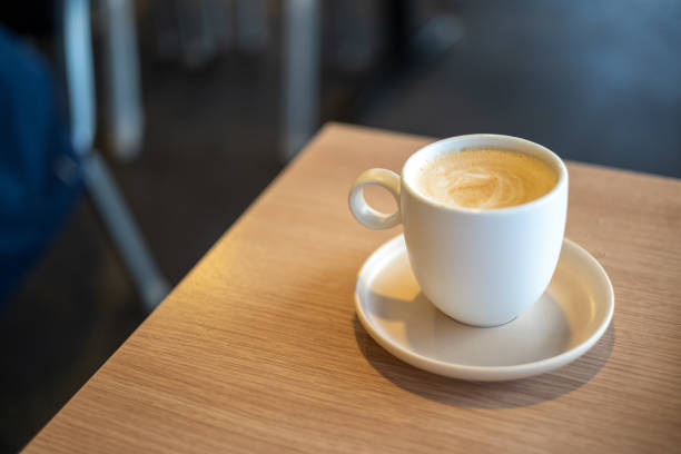 Frothy milk coffee on top of wooden table