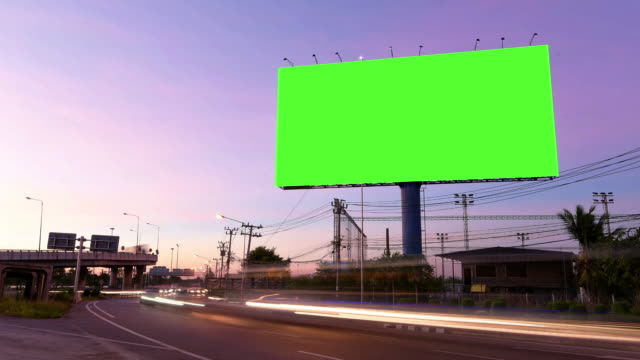 Time Lapse of Blank Billboard with a Green Screen on Night Street with light trails
