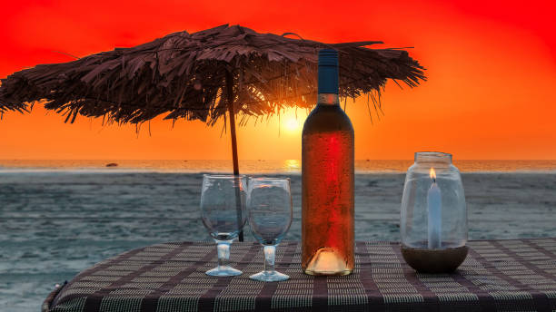 Beach party at sunset Sunset view of beach party in beach cafe with bottle of rose wine and glasses on the table , GOA, India. beach goa party stock pictures, royalty-free photos & images