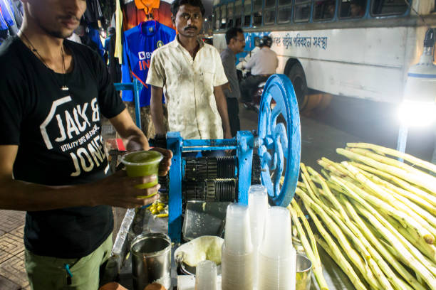 November 29, 2019- Kolkata: Seller extracting sugar cane juice on roadside cart in Kolkata,India.