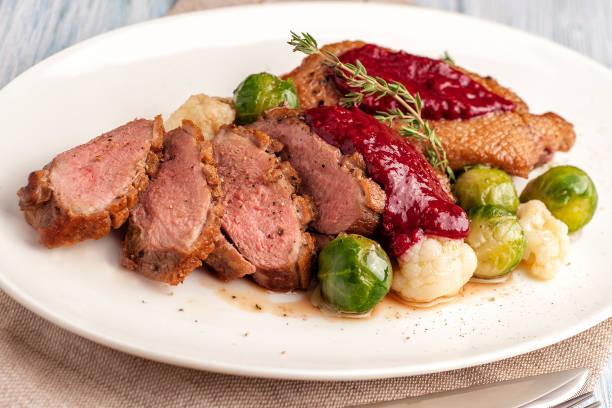 Roasted duck breast with vegetable garnish. stock photo