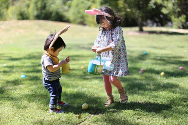 dziewczyna i chłopiec zbieranie pisanki - easter baby rabbit eggs zdjęcia i obrazy z banku zdjęć