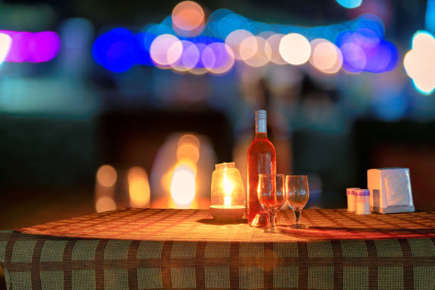 Beach party at night and blur background Night view of beach party in beach cafe with bottle of rose wine and glasses on the table and night illumination, GOA, India. beach goa party stock pictures, royalty-free photos & images