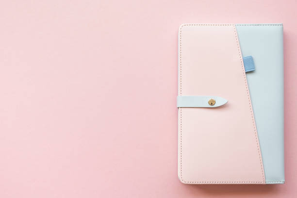 istock Close pink and blue note book on light pink background, copy space, top view 1204552739