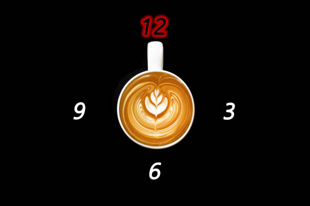 istock A white coffee mug on a black background with a glass handle pointing to twelve numbers 1204557721
