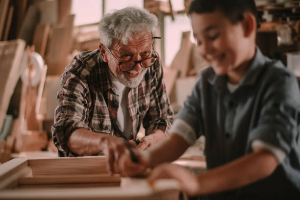 istock Senior carpenter and his grandson having fun in the workshop 1204559345