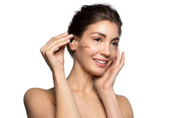 istock Brunette woman with pipette applying serum on face 1204564205