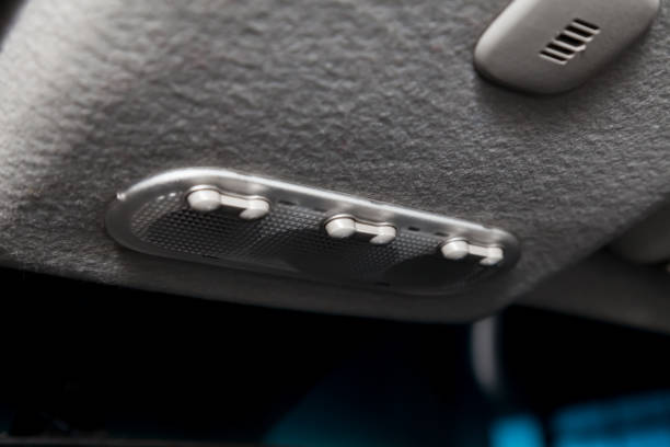istock Lighting control inside the car from the top on the instrument panel behind the rear-view mirror in white with buttons. Auto service industry. 1204564710