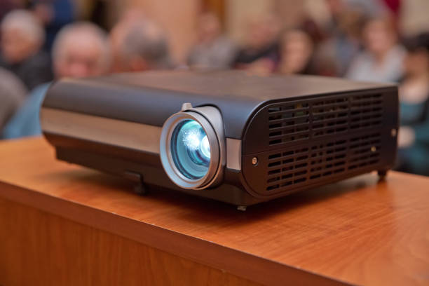 istock LCD video projector at business conference or lecture in office with copy space. projector on ceiling indoors. 1204564897