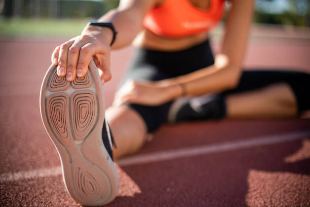 istock Woman stretching on running track 1204568587