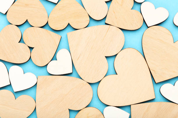 istock Brown and white wooden hearts on blue background 1204568596