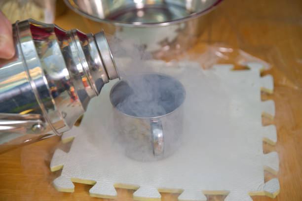 istock Chemical experiment, show with liquid nitrogen . researcher in uniform and goggles is conducting an experiment with liquid . Steam of Nitrogen Created from Liquid Nitrogen Exposed to Temperatures . 1204569005
