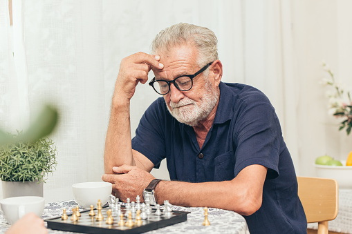 Man thinking about his next move while playing a game of chess against an unseen opponent