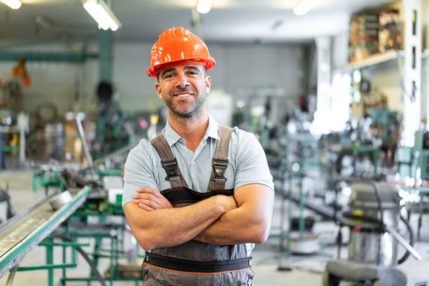 istock Foreman standing in factory with arms crossed 1204573453