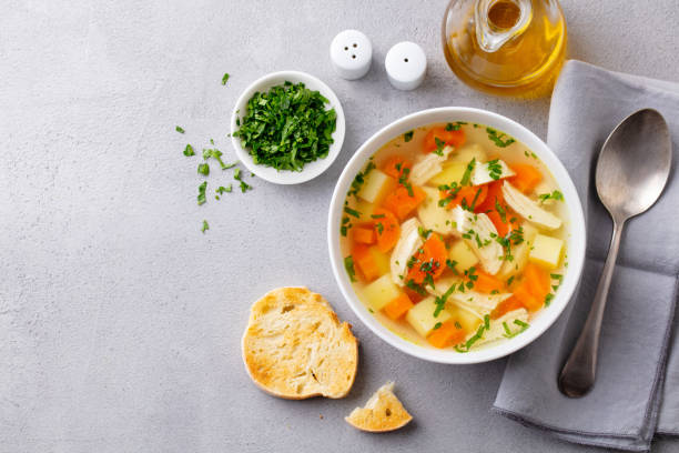 istock Chicken soup with vegetables in white bowl. Grey stone background. Copy space. Top view. 1204577223
