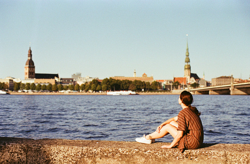 Young Caucasian woman  looking at scenic  view of Riga old town