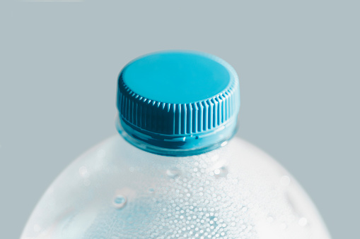 Three PET plastic bottles are stacked inside each other. Absurd outdoors still life. CGI