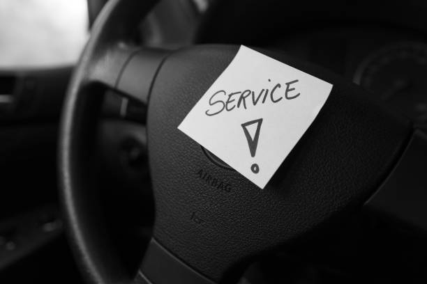 istock Writing service on memo post reminder. Text on sticky paper inside car dashboard. 1204580499