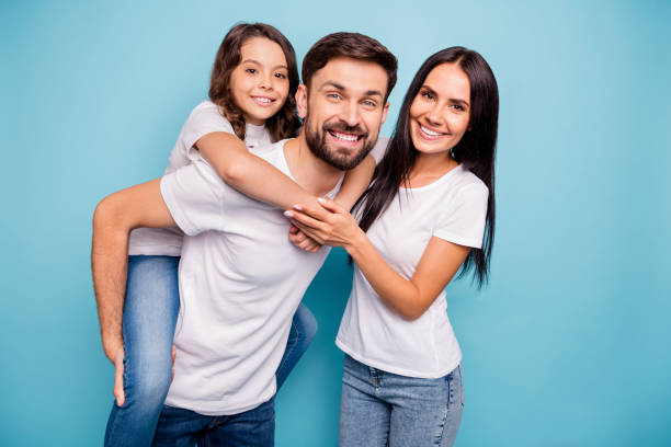 retrato de funk alegre positivo três pessoas carregam kid piggyback curtir fins de semana usar jeans jeans jeans de camisa branca isolado sobre fundo de cor azul - wife mother offspring daughter - fotografias e filmes do acervo