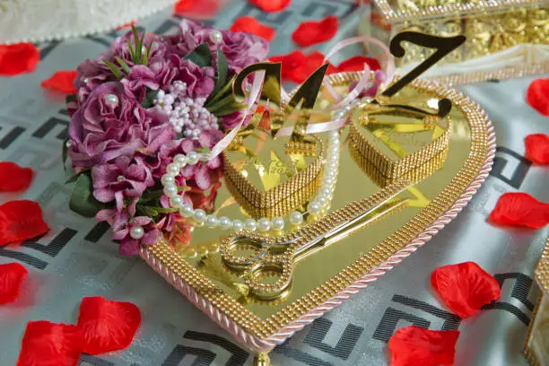 Gold-colored heart mirror . Pink flower for engagement . The letters Z and M