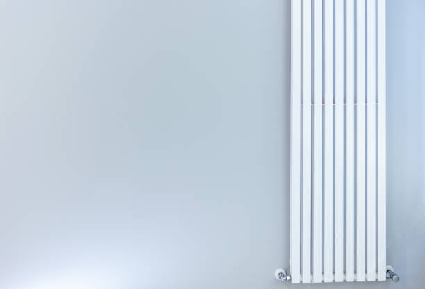 istock white radiator on gray wall in office 1204585727