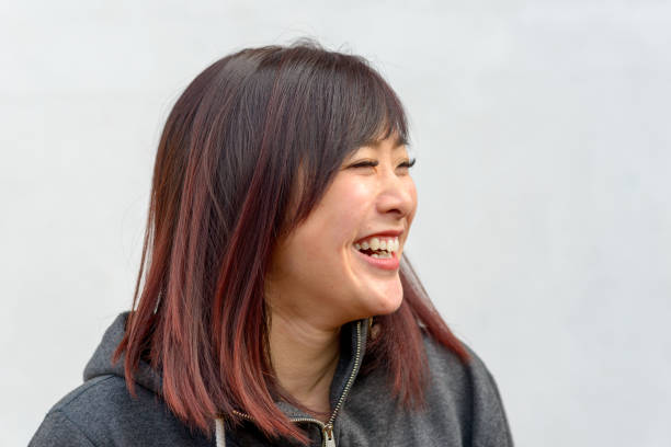 istock Happy vivacious young Asian woman grinning 1204587419