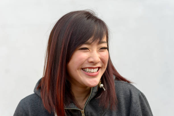 istock Happy vivacious young Asian woman grinning 1204587457