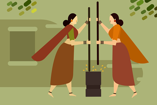 Two women milling rice in the old traditional way