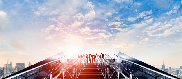 Success of business concept. Group of businessperson on the top of stairs.