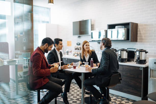 istock Latino employees taking a break at work, eating snack and chatting. 1204590051